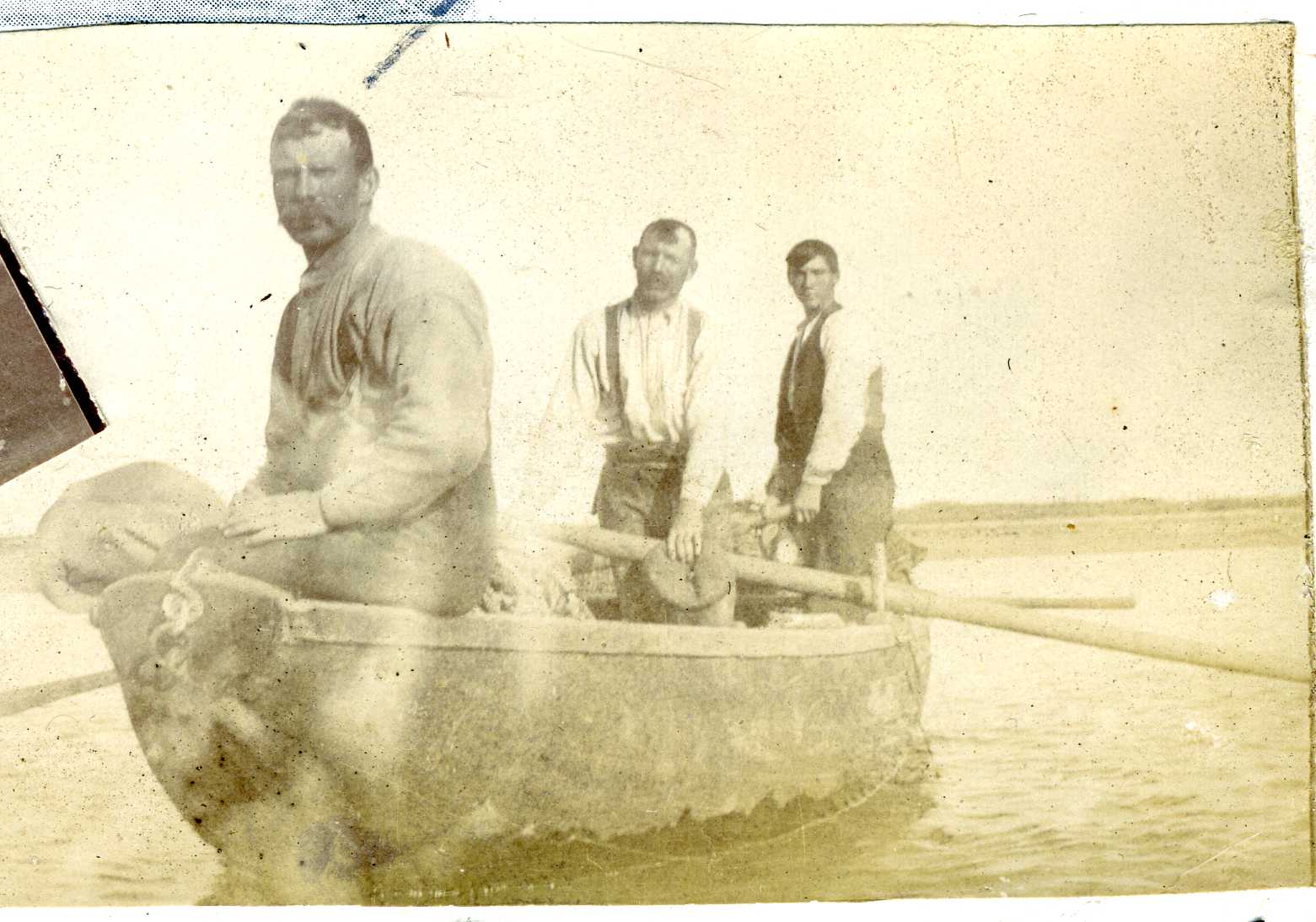 3 men in a fishing boat in 1908.